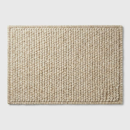 Chunky knit neutral rug with thick textured oversized yarn loops for cozy Scandinavian interiors