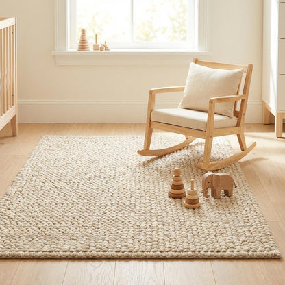 Chunky knit neutral rug with thick oversized yarn loops and warm natural fiber texture for cozy Scandinavian interiors