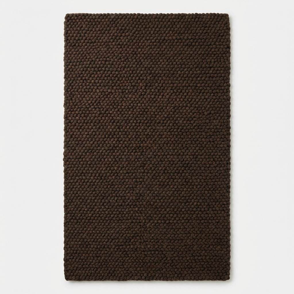 Chunky knit rug in dark brown with thick braided roving texture for cozy modern organic interiors