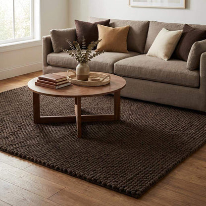 Chunky knit rug in dark brown with thick braided roving texture for cozy modern organic interiors
