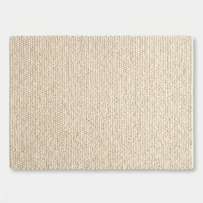 Chunky knit wool rug in cream with thick looped texture and plush soft surface for cozy, neutral floor accent