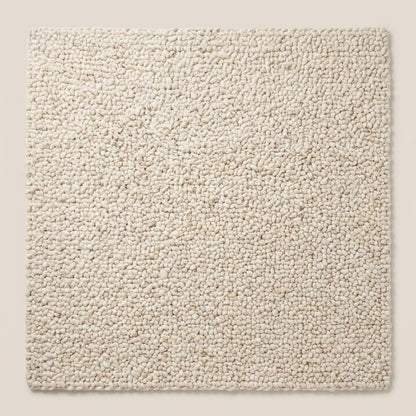 Handwoven chunky knit wool rug in soft ivory with thick loops for cozy, textured minimalist living room decor