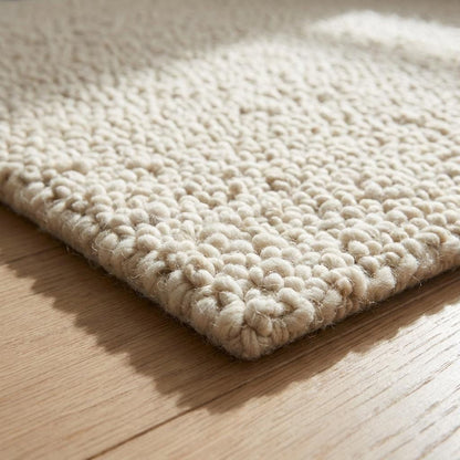 Handwoven chunky knit wool rug in neutral ivory with thick soft loops, cozy minimalist boho living room carpet