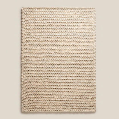 Handwoven chunky wool area rug with oversized knit pattern, soft neutral beige rug perfect for modern minimalist interiors.