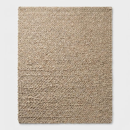 Chunky knit wool rug with thick, plush loops in neutral tones for cozy Scandinavian home decor