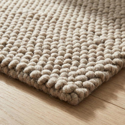 Chunky knit wool rug with thick plush texture in neutral tones for cozy Scandinavian home decor