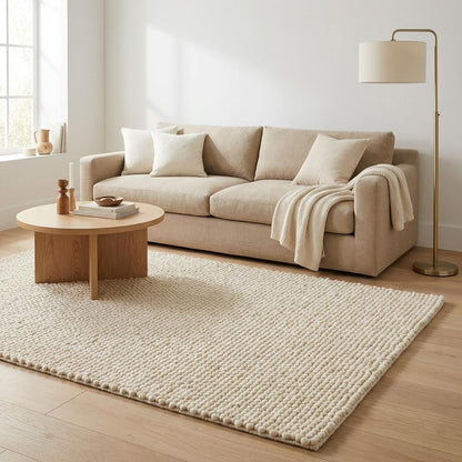 Chunky knit wool rug with thick, plush loops in neutral cream tone, perfect for cozy living rooms and nurseries.