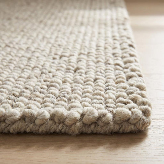 Chunky knit wool rug with thick neutral loops, soft textured luxury floor covering for cozy modern home decor.