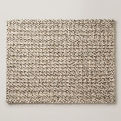 Chunky knit wool rug with thick neutral wool loops in cozy modern living room setting