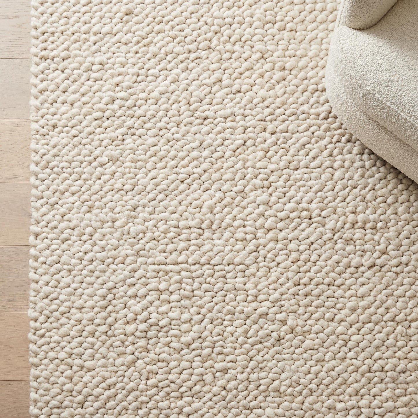 Handmade chunky knit wool rug with thick ivory loops for cozy minimalist Scandinavian decor
