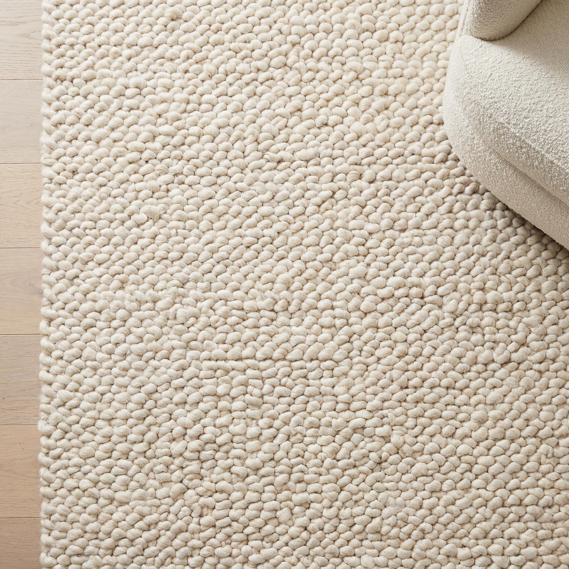 Handmade chunky knit wool rug with thick ivory loops for cozy minimalist Scandinavian decor