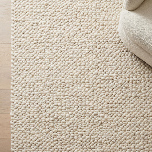 Handmade chunky knit wool rug with thick ivory loops for cozy minimalist Scandinavian decor