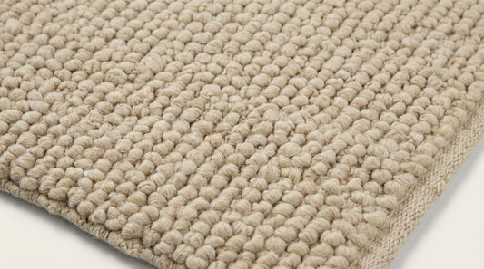 Chunky knit wool rug in cream beige with thick handmade textured loops for cozy home decor