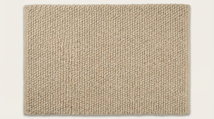 Chunky knit wool rug in cream beige with thick hand-knit texture and plush wool strands