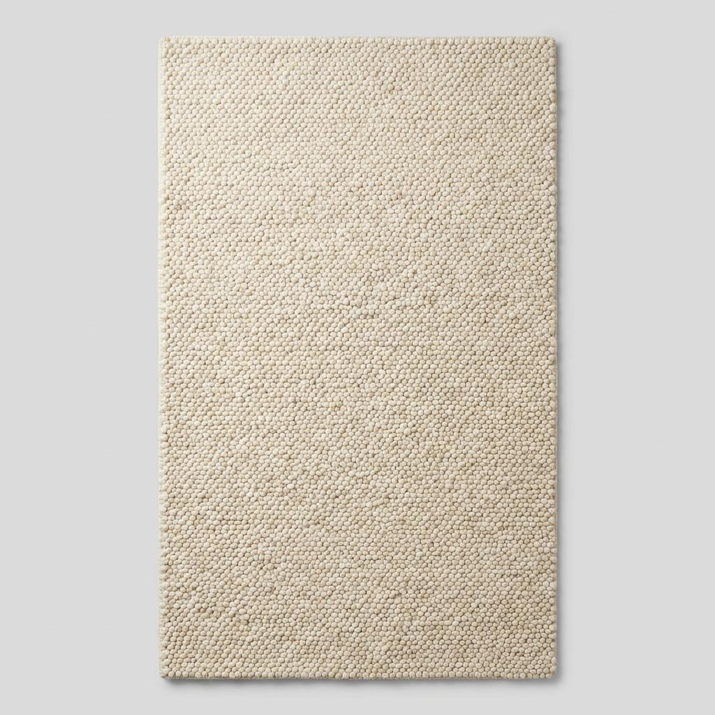 Ivory chunky knit wool rug with thick braided texture and soft natural fibers