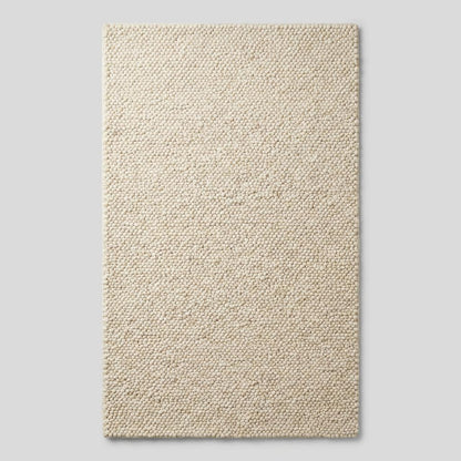 Ivory chunky knit wool rug with thick braided texture and soft natural fibers
