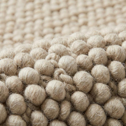 Chunky loop textured cream area rug with plush, nubby surface in modern organic living room setting
