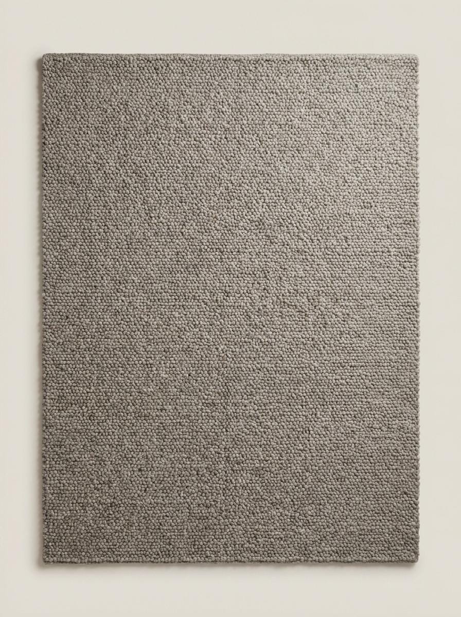 Chunky loop textured neutral rug with thick yarn and cozy Scandinavian style in minimalist living room