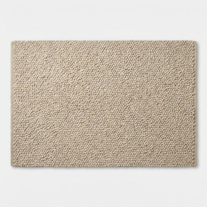 Chunky loop textured neutral area rug with braided edge, soft cushioned underfoot feel, modern organic cozy floor accent