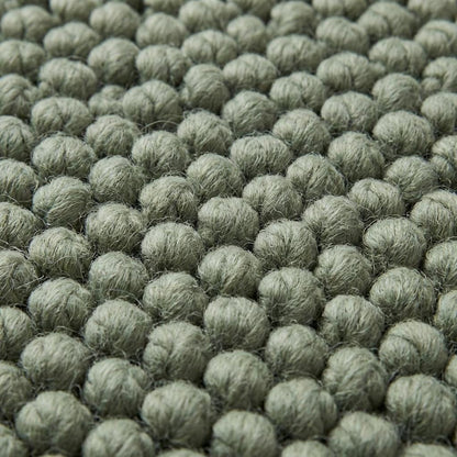 Chunky loop textured sage green rug with thick cozy loops in minimalist modern room