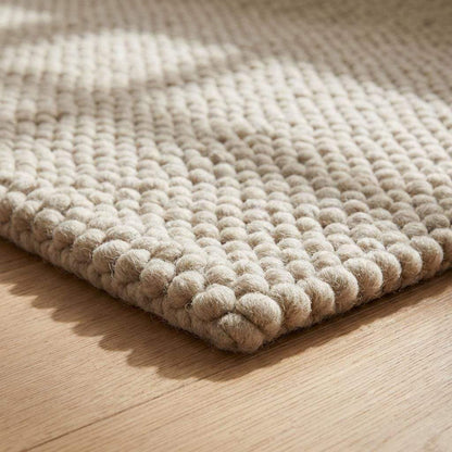 Detailed edge binding of thick woven cream rug