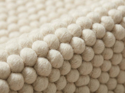 Chunky wool ivory area rug with thick textured oversized loops in Scandinavian neutral living room setting