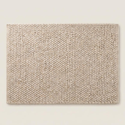 Top view of neutral chunky knit style rug with sculptural braided texture