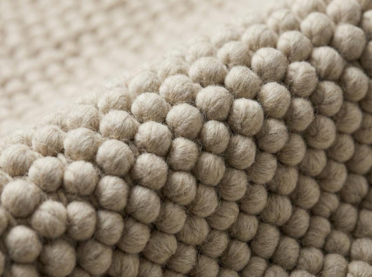 Close-up detail of thick oversized wool loops showing pebble-like texture
