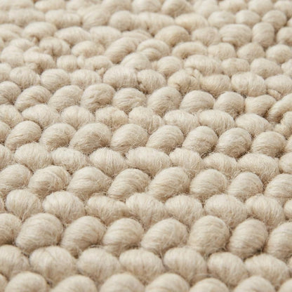 Chunky wool loop rug in cream with thick textured yarn loops, handcrafted cozy area rug for modern organic interiors