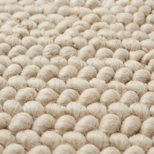 Chunky wool loop rug in cream with thick textured yarn loops, handcrafted cozy area rug for modern organic interiors