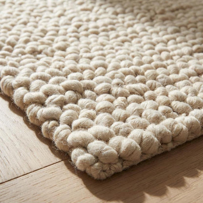 Chunky wool loop rug in cream with oversized yarn loops and textured, cozy design for modern organic interiors