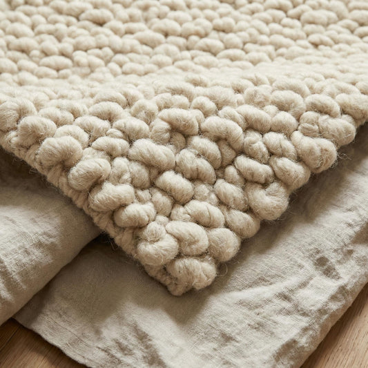 Handcrafted chunky wool loop rug in cream with thick plush texture for cozy neutral home decor