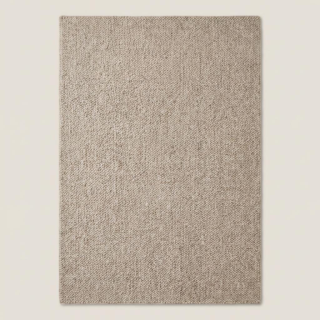 Handwoven chunky wool loop rug in neutral beige with thick texture for cozy minimalist Scandinavian home decor