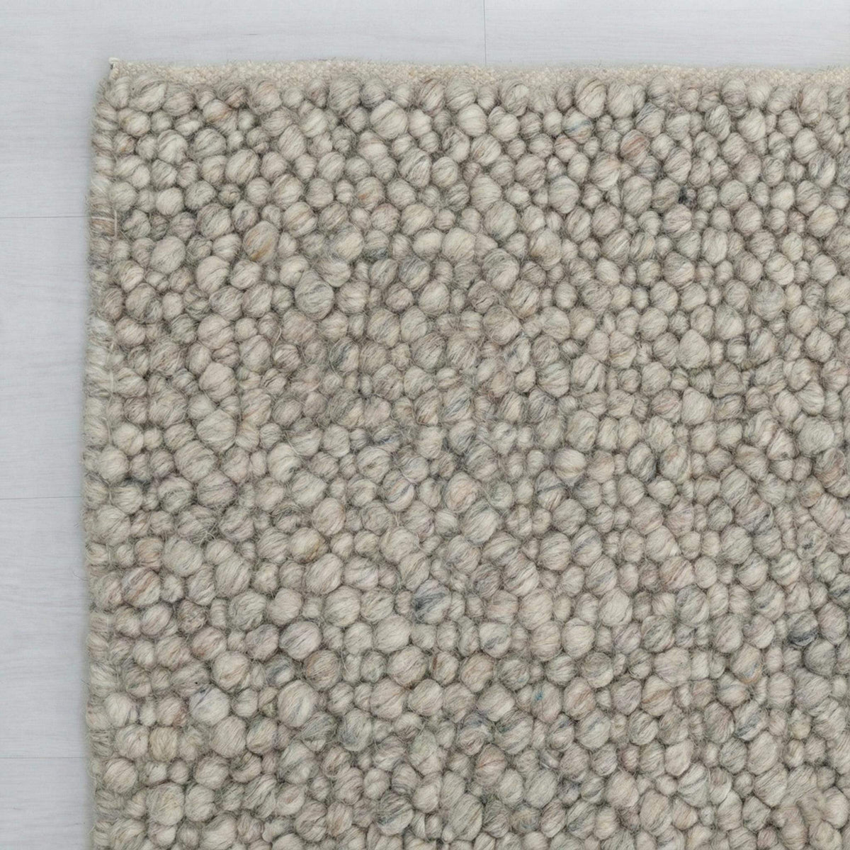 Chunky wool loop rug with pebble texture in neutral tones for cozy Scandinavian decor