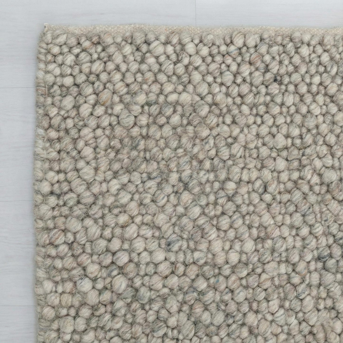 Chunky wool loop rug with pebble texture in neutral tones for cozy Scandinavian decor