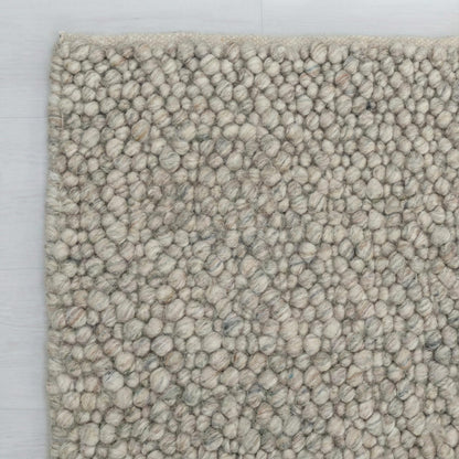 Chunky wool loop rug with pebble texture in neutral tones for cozy Scandinavian decor
