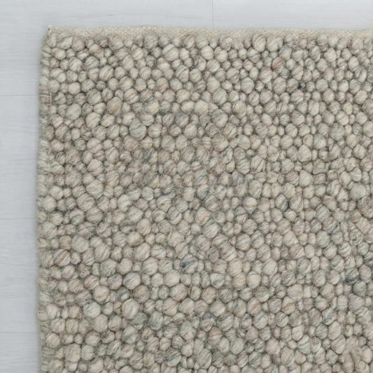 Chunky wool loop rug with pebble texture in neutral tones for cozy Scandinavian decor