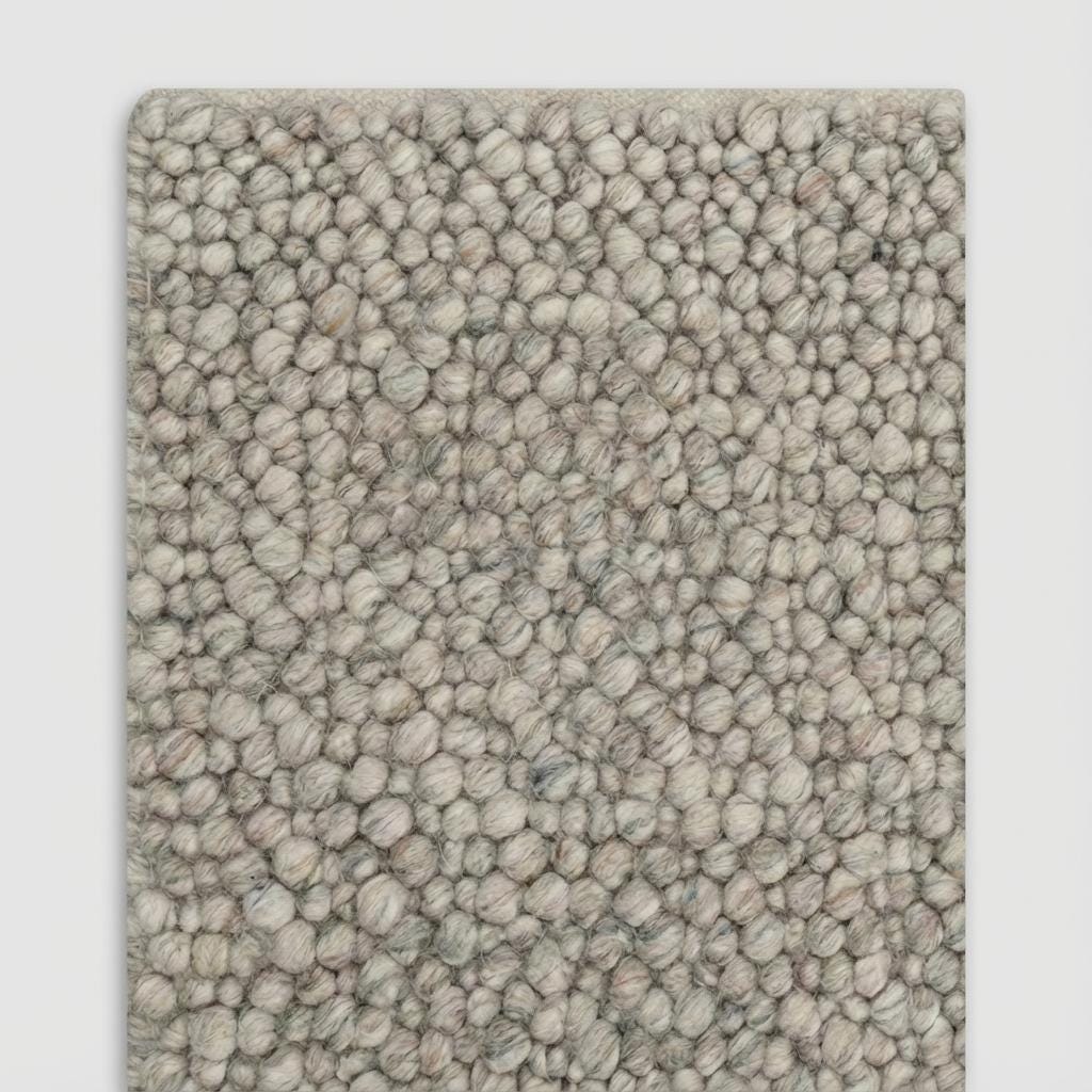 Neutral chunky wool loop carpet featuring organic pebble weave pattern for cozy home styling and warm floor texture.