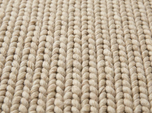 Chunky wool neutral area rug with thick knit texture in a cozy modern living room setting