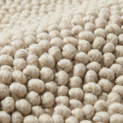 Chunky wool neutral area rug with thick textured cream loops in cozy modern interior