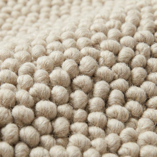 Chunky wool neutral area rug with thick textured cream loops in cozy modern interior