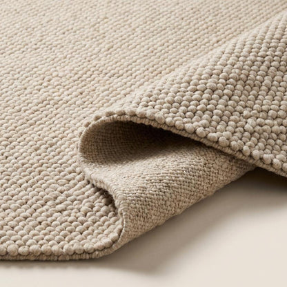 Handmade chunky wool rug with thick cream loop pile, cozy neutral textured floor carpet for boho and modern interiors