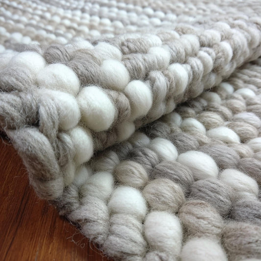 Handwoven chunky wool rug in neutral tones with thick, cozy texture for Scandinavian and modern living spaces