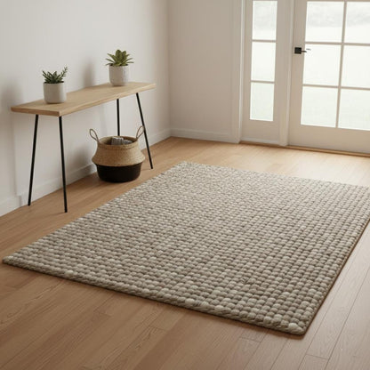 Handwoven chunky wool rug in neutral tones with thick, textured felted wool for cozy Scandinavian living room decor