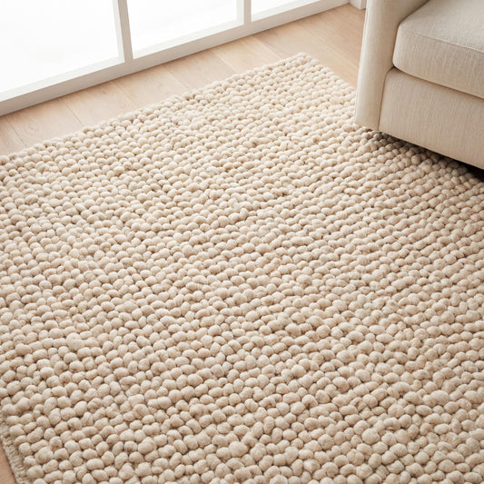 Handmade chunky wool rug in neutral beige with soft, textured, cozy design for boho and minimalist home decor