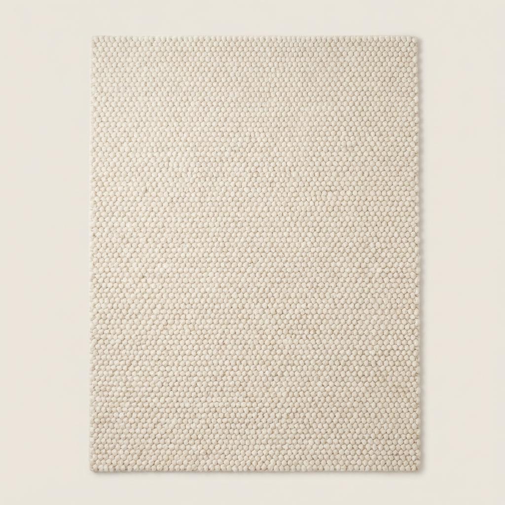 Chunky wool rug with neutral loop pile texture in minimalist living room