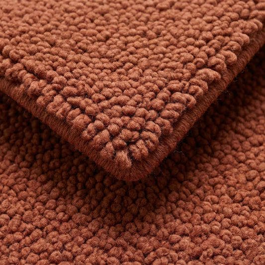 Chunky wool rug in warm rust tone with plush, textured loops for cozy living room or bedroom comfort