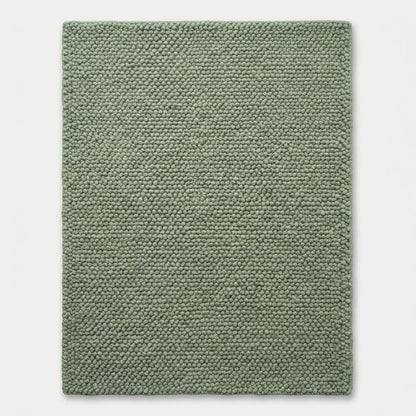 Chunky wool textured sage green area rug with thick looped plush surface for cozy modern organic interiors