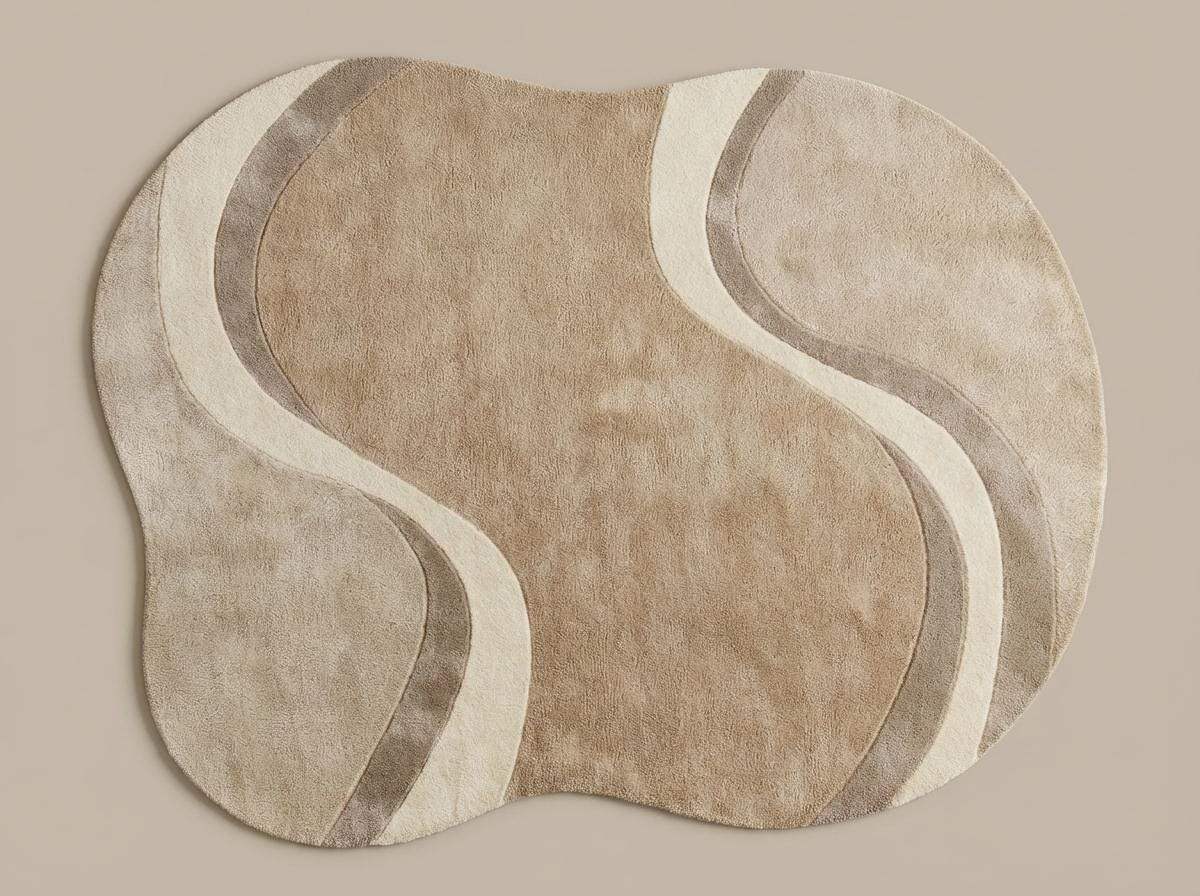 Modern curved rug living room with wavy abstract pattern in beige, cream, and taupe organic shape