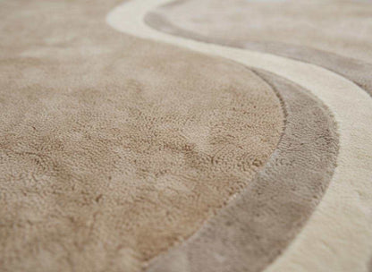 Modern curved rug living room with beige wavy pattern and organic shape, hand-tufted for soft comfort and neutral Japandi style decor.